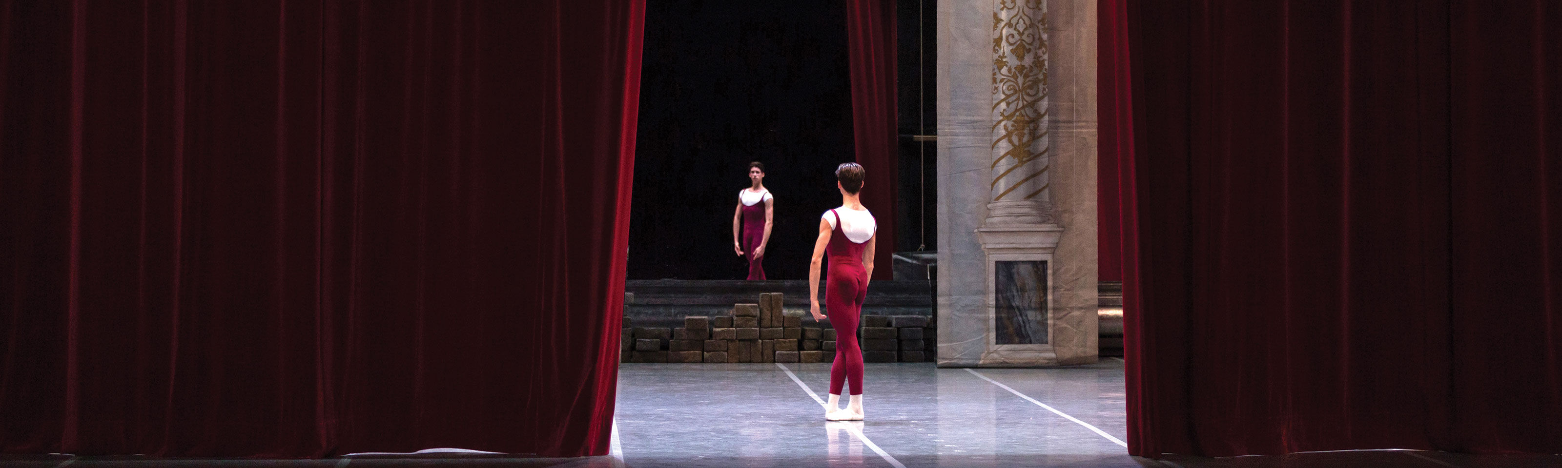 Young dancers in red academic, ready on stage at curtain opening